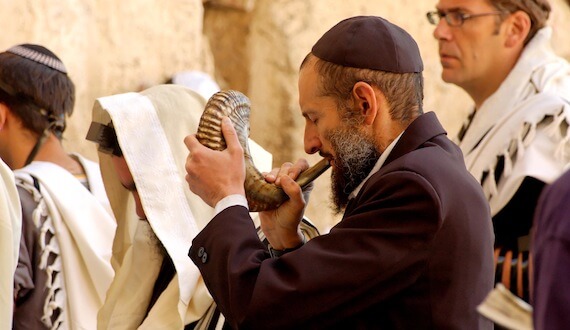 Man blowing shofar during Elul at Western Wall.